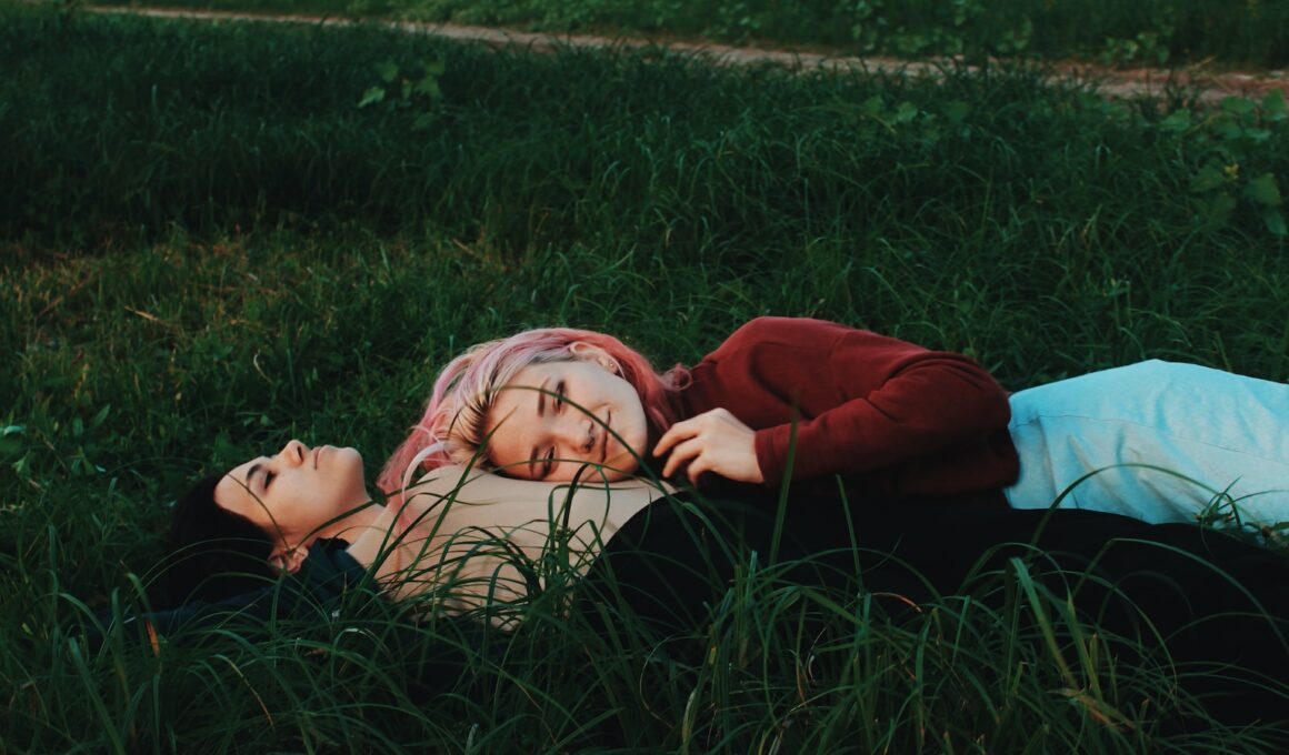 two women lying on green grass