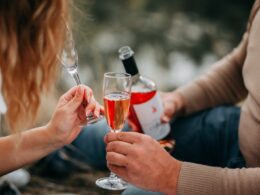 Two Persons Holding Glass Flutes While Drinking