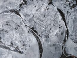 Top view of fragile ice broken into small thin transparent pieces in frosty weather