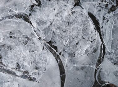 Top view of fragile ice broken into small thin transparent pieces in frosty weather