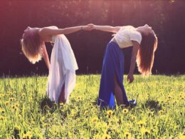 two women bending while holding hands