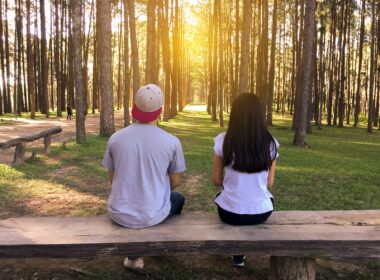 Man and Woman Sitting on Bench in Woods