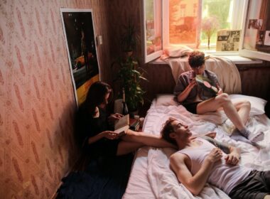 Man in Blue T-shirt Lying on Bed Beside Woman in Green T-shirt