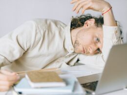 Overworked Employee lying in front of Laptop