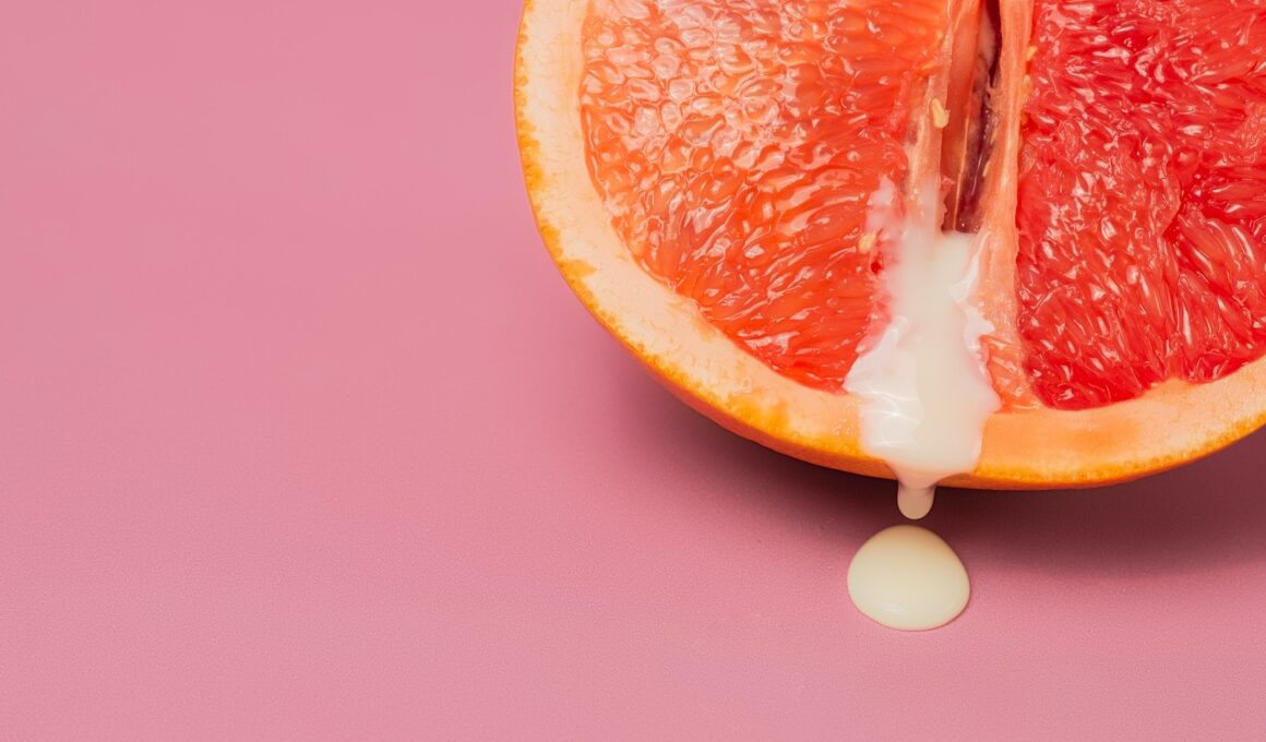 High angle of closeup of half of fresh orange grapefruit as symbol of vagina with sperm placed on pink surface in studio