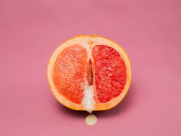 Sexy grapefruit with sperm against pink background