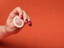 person holding clear drinking glass with yellow liquid