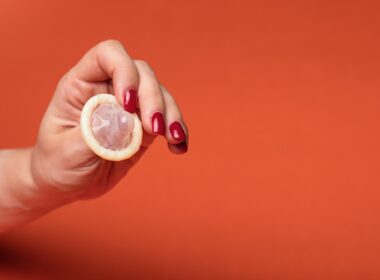 person holding clear drinking glass with yellow liquid