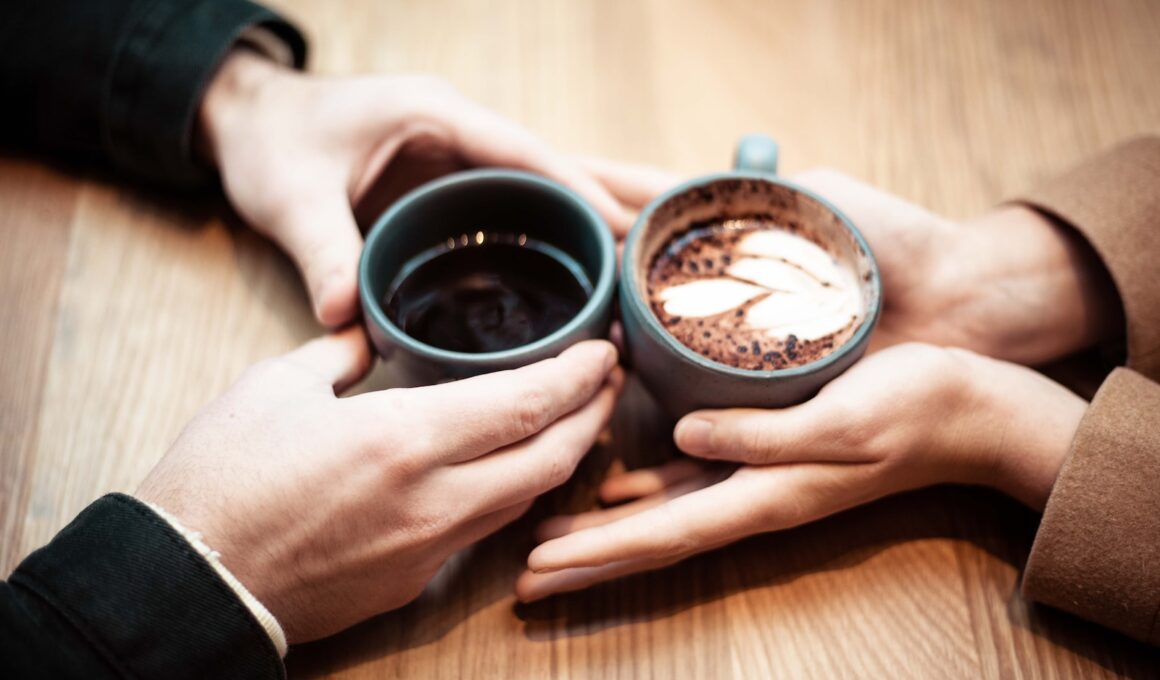 two person holding ceramic mugs with coffee