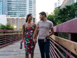 man and woman standing on wooden bridge during daytime