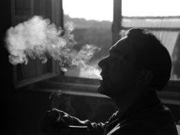 person smoking beside window