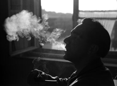 person smoking beside window