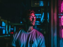 man looking at glass storefront windowpane during night