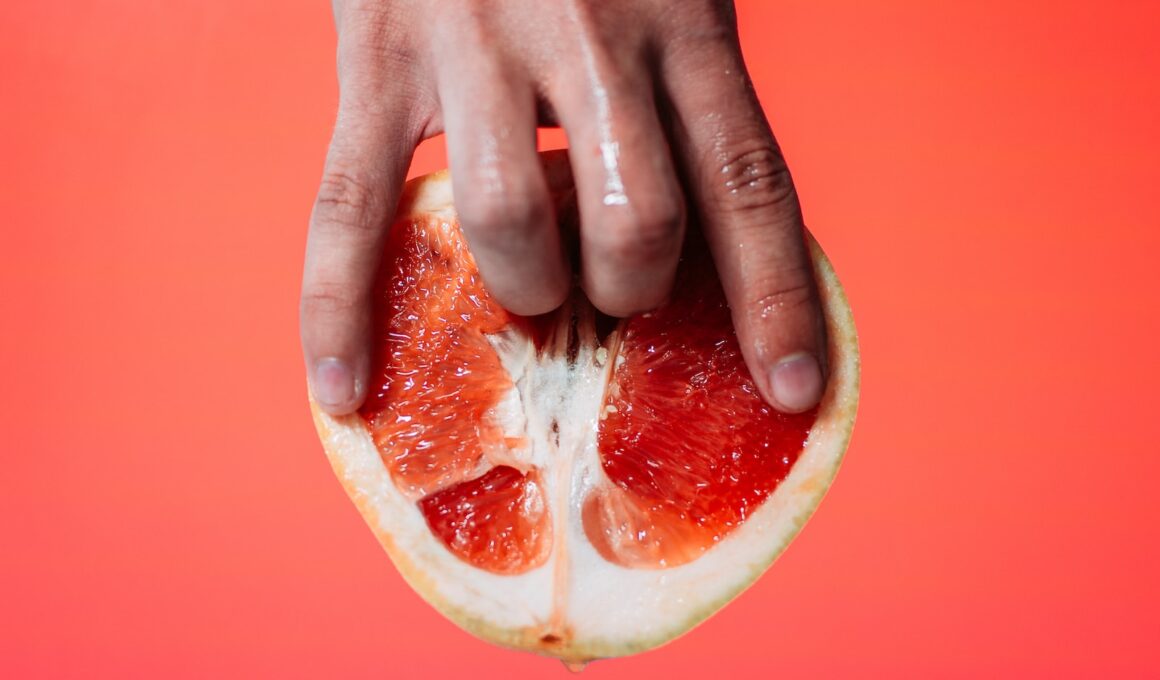 person holding red pomelo fruit