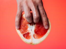 person holding red pomelo fruit