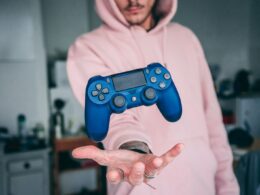 person holding blue Sony PS4 Dualshock 4 c