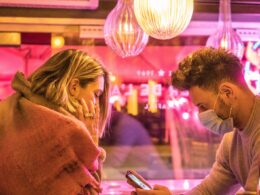 woman in white long sleeve shirt holding smartphone