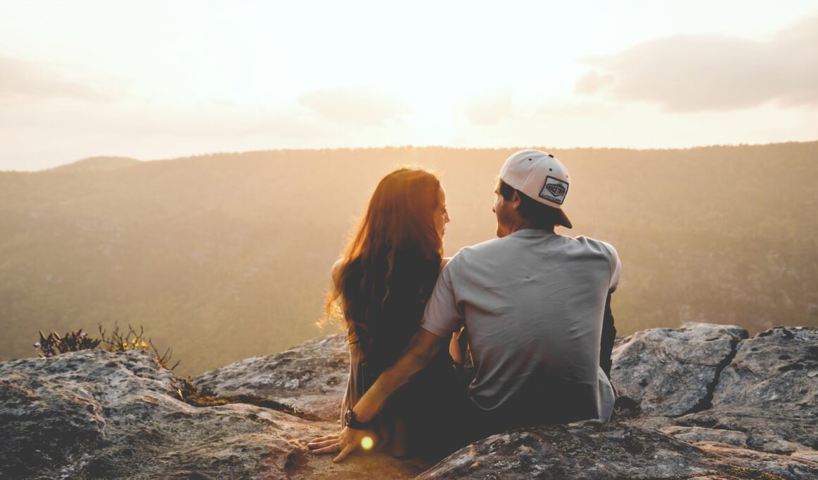 man and woman sitting on rock during daytime