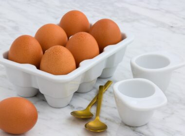 tray of brown eggs beside two spoons