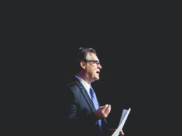 a man in a suit and tie holding a piece of paper