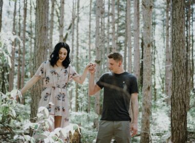 man holding hands with woman near trees